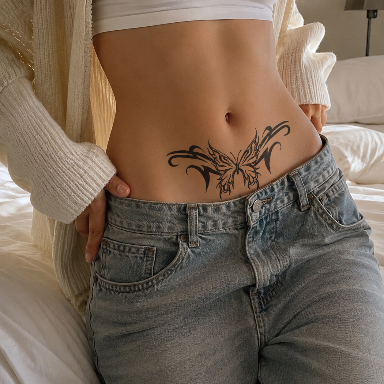Woman wearing the Midnight Temptation succubus temporary tattoo above low-rise jeans