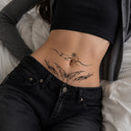 Woman wearing the Starlit Veil succubus temporary tattoo on the lower stomach with black jeans