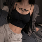 Woman wearing the Thorn Oath succubus chest temporary tattoo with a black cropped cami