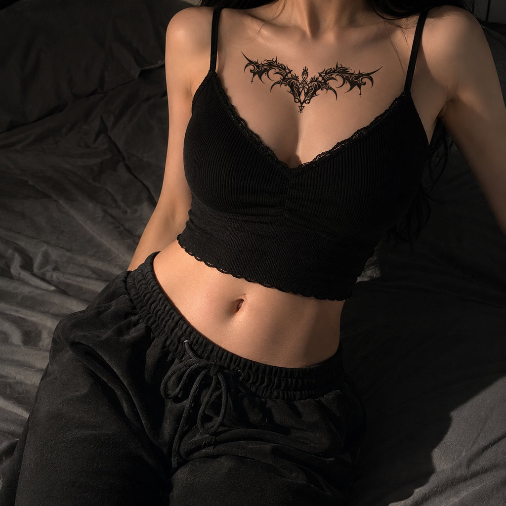 Woman wearing the Nightfang succubus chest temporary tattoo with a black lace camisole
