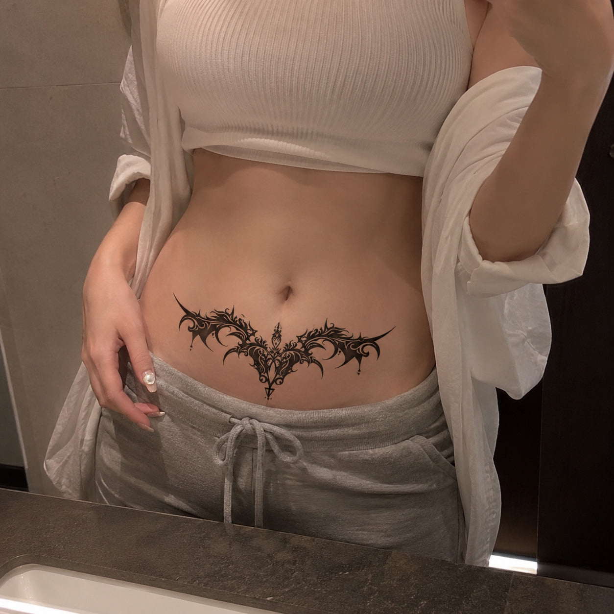 Nightfang gothic bat wing temporary tattoo worn on the lower stomach