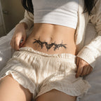 Woman wearing the Shadowthorn thorn wing temporary tattoo on the lower stomach