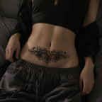 Woman wearing the Baroque Noir ornamental temporary tattoo centered across the upper chest