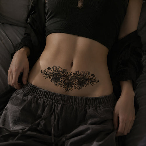 Woman wearing the Baroque Noir ornamental temporary tattoo centered across the upper chest