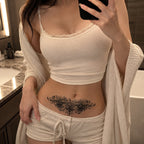 Woman wearing the Baroque Noir elegant black temporary tattoo on the lower stomach