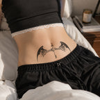 Woman wearing the Shadow Key black bat wings temporary tattoo on the lower stomach