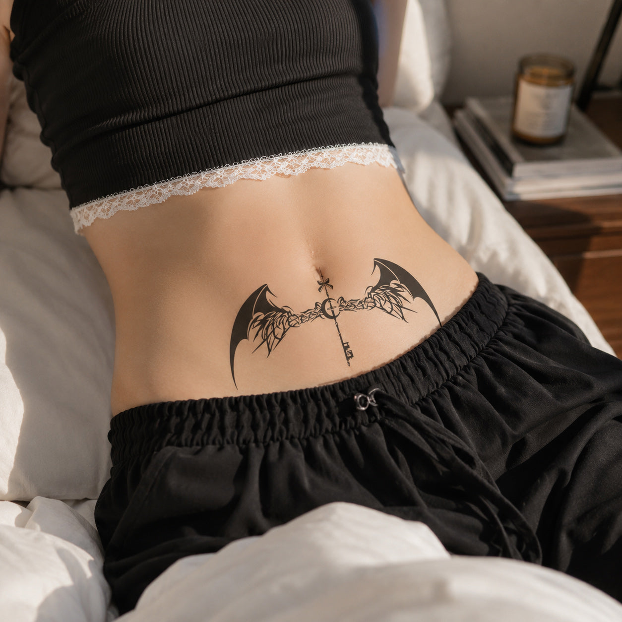 Woman wearing the Shadow Key black bat wings temporary tattoo on the lower stomach