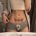 Shadow Spear gothic bat wings temporary tattoo centered across the lower abdomen