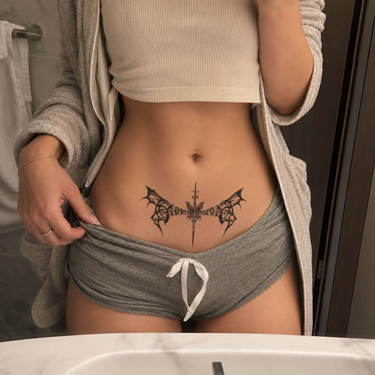 Shadow Spear gothic bat wings temporary tattoo centered across the lower abdomen