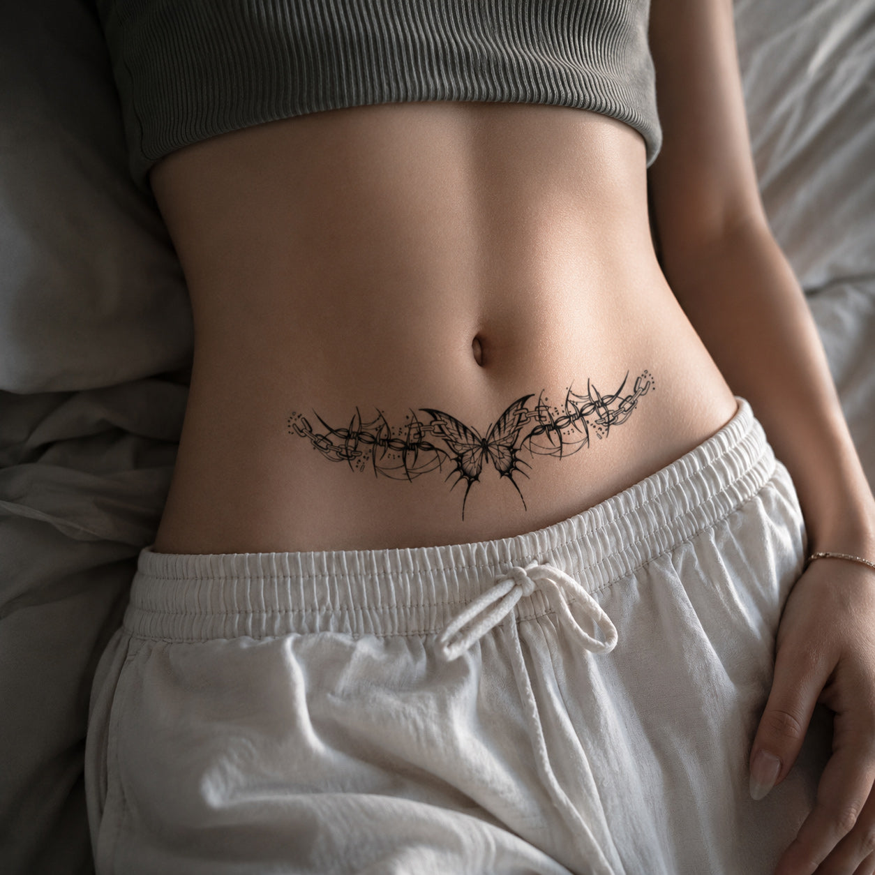 Woman wearing the gothic butterfly chain temporary tattoo on the lower abdomen