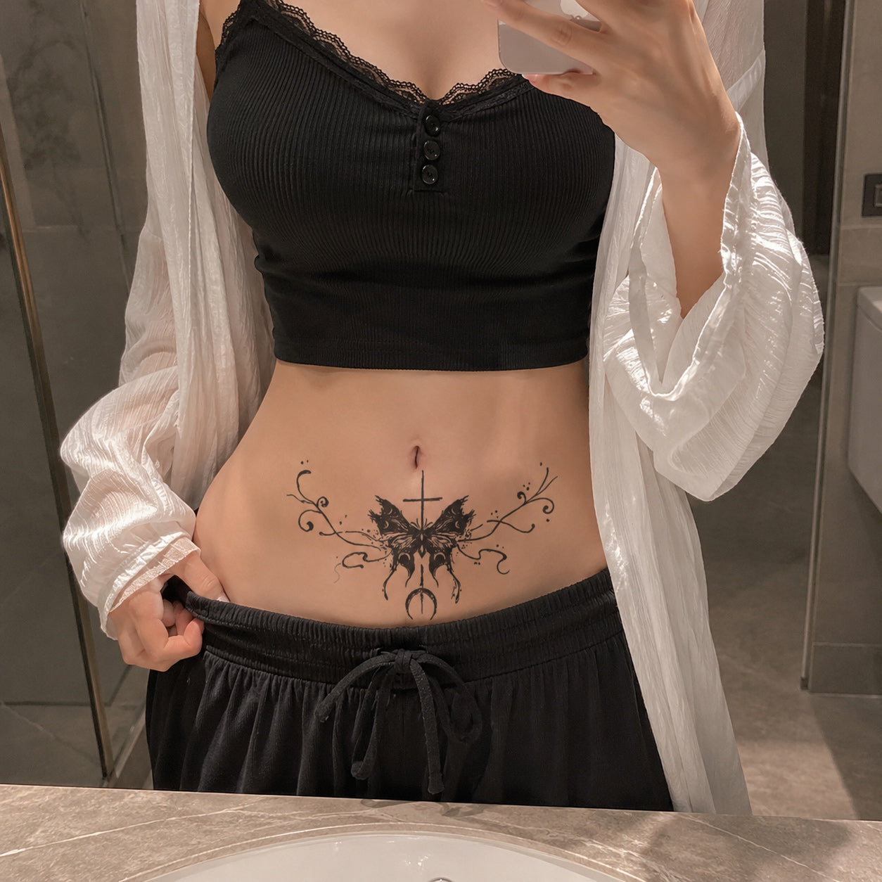 eclipse cross butterfly temporary tattoo applied above the lower stomach in gothic black ink style