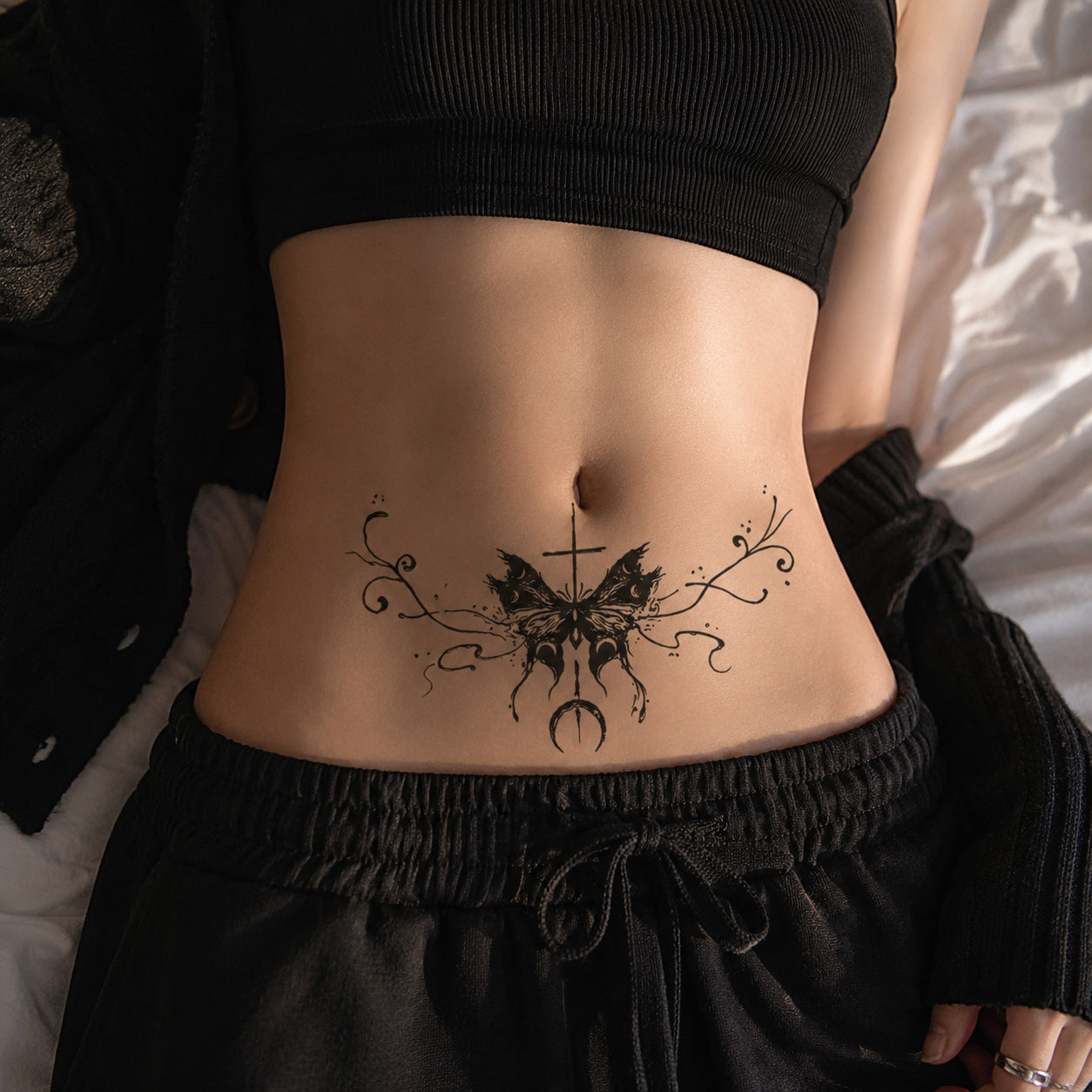 close-up of gothic eclipse cross butterfly temporary tattoo on the lower abdomen