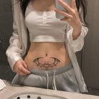 bat wing heart temporary tattoo applied above the lower stomach in black gothic style