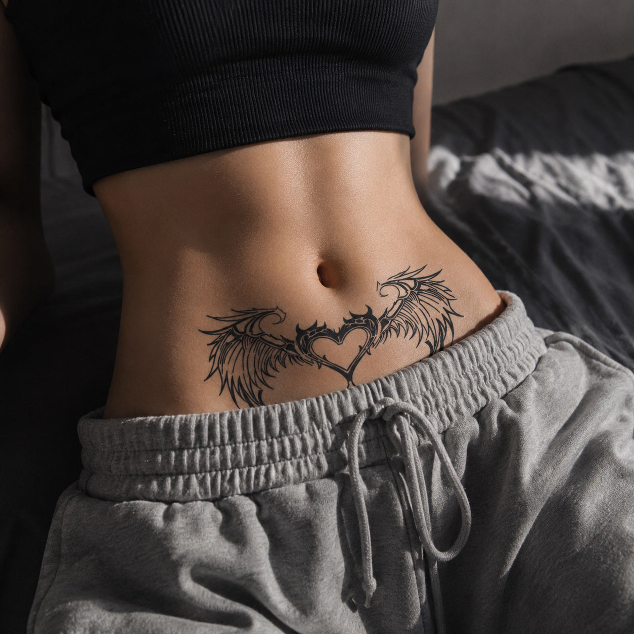 close-up of celestial wing heart succubus temporary tattoo on the lower abdomen