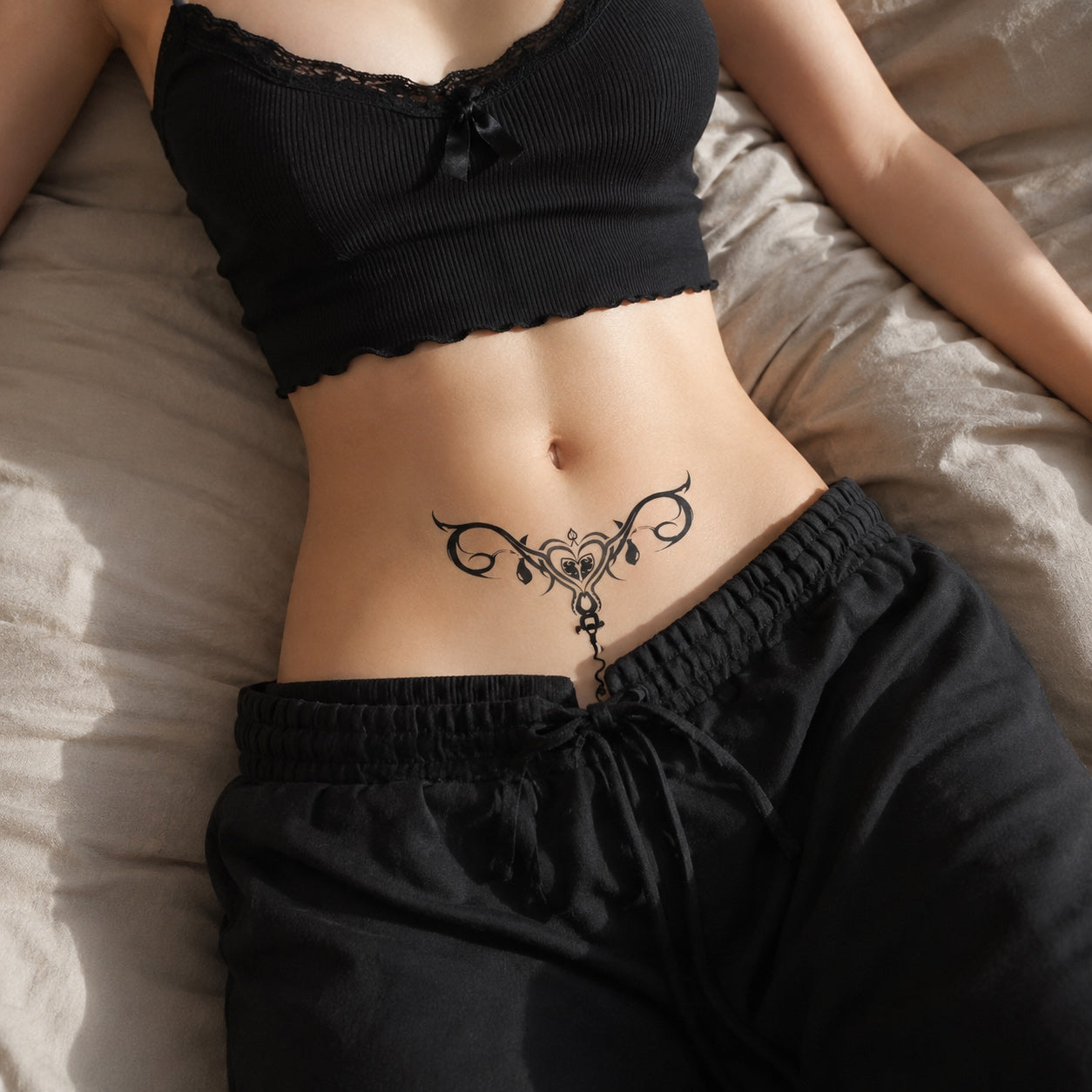 close-up of dark siren succubus temporary tattoo on the lower abdomen with gothic ornamental design